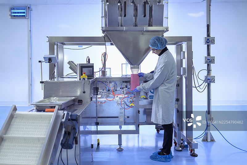 制药厂工人将药品包装到药包内图片素材