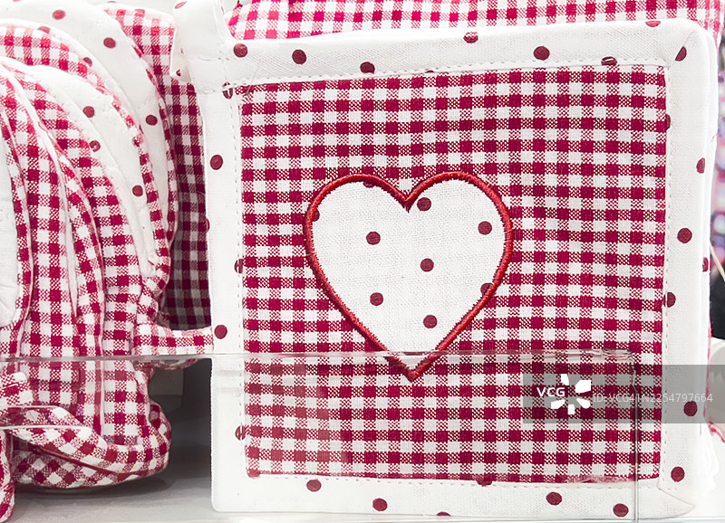 用于烤盘的烤箱手套抹布。红白格子图案，中心有一个心形。图片素材