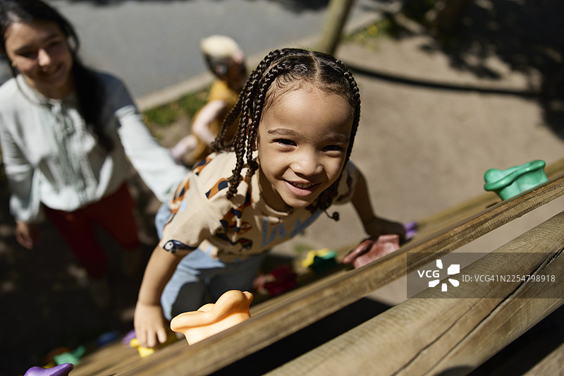 留着编发的男孩爬墙图片素材