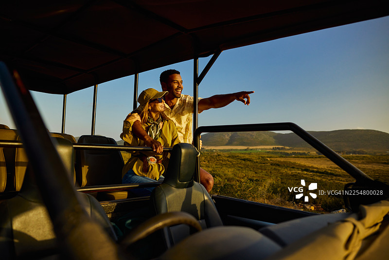 一对快乐的夫妇在享受野生动物园之旅，观察野生动物图片素材