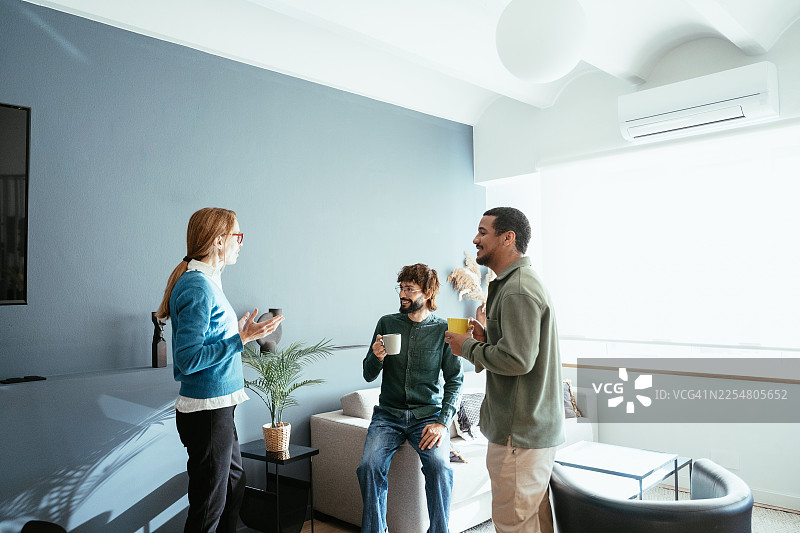 经验丰富的高管在咖啡休息时间与同事在现代办公室交谈图片素材