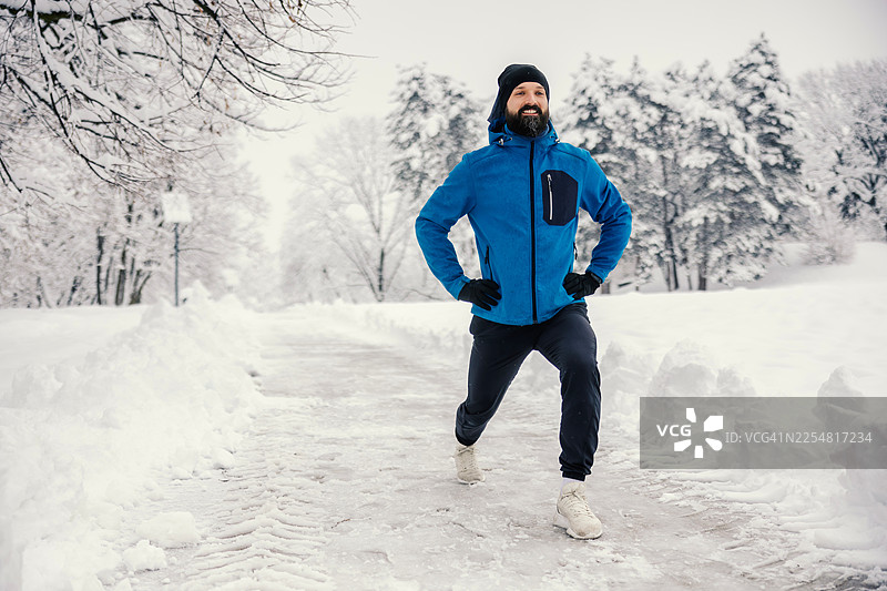 冬季户外锻炼中做弓步的男人图片素材