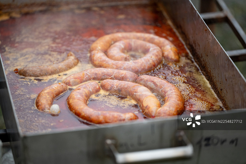 烤香肠放在油腻的金属托盘上，配有锡纸图片素材