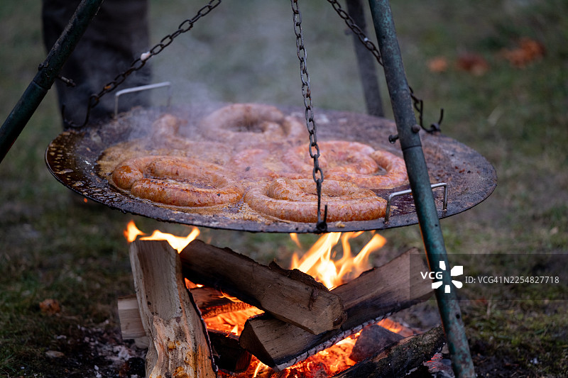 烤香肠放在油腻的金属烤盘上，铺有铝箔图片素材