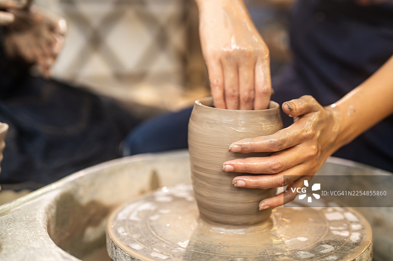 女人的手在陶轮上塑造黏土图片素材