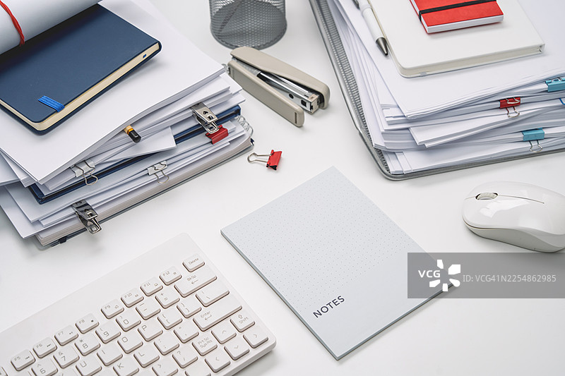 办公桌上的白色文具。充满文件的工作氛围。空白笔记本图片素材