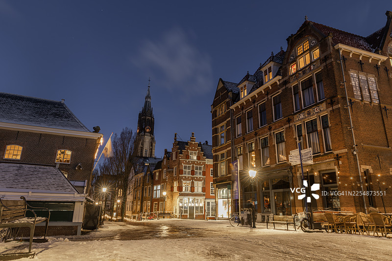 雪覆盖的代尔夫特道路和建筑，在冬日蓝天的夜晚图片素材