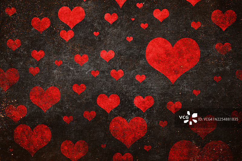 红色爱心散落在黑暗、做旧的复古风情人节背景上，浪漫抽象纹理图片素材