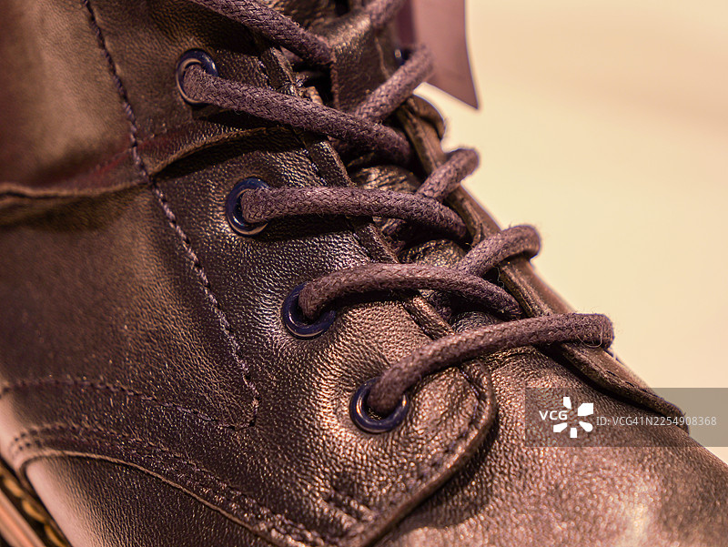 深色皮革冬靴的鞋带和孔眼细节图片素材