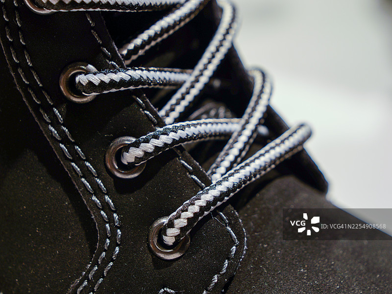 黑色冬季靴子，特写镜头，带有对比色鞋带图片素材