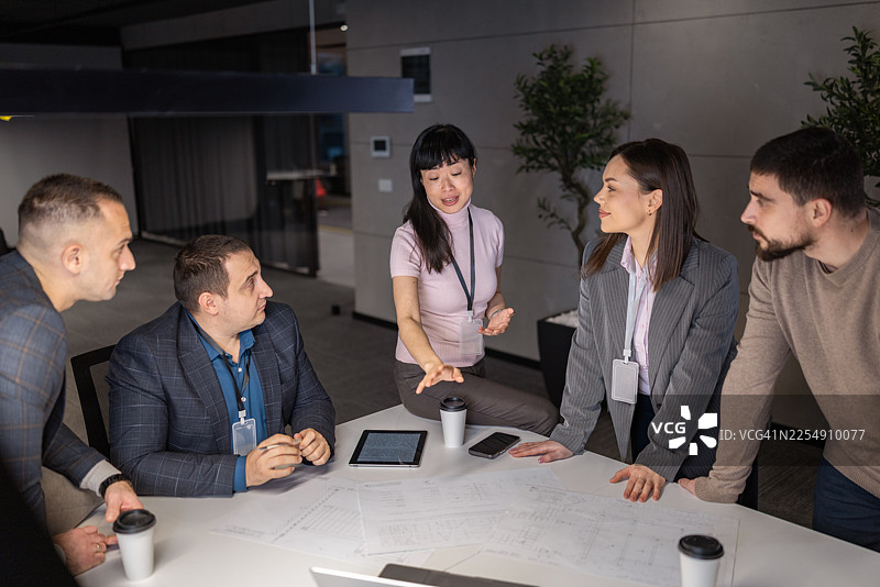 一群多元化的专业人士在现代办公室协作处理文件图片素材
