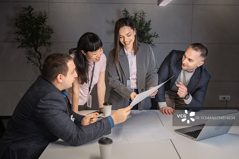 一群来自不同背景的专业人士在现代办公室协作处理文件图片素材