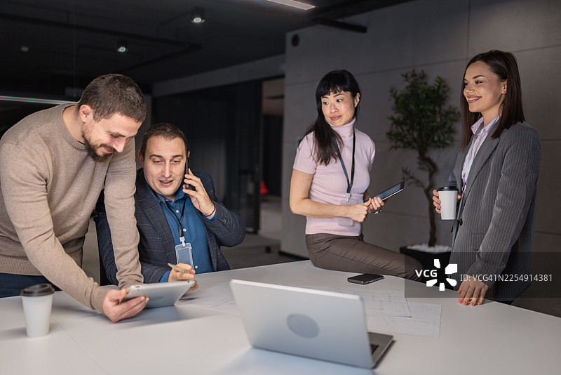 专注的男专业人士在平板电脑上讨论数据并接听电话图片素材