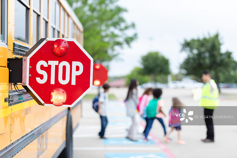 校车停靠站标志帮助儿童在放学时穿过繁忙的街道图片素材