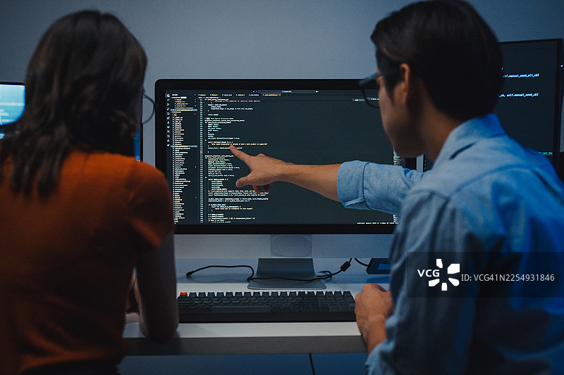 科技团队的亚洲专业人士在现代办公室深夜协作，讨论软件开发策略。加班加点，软件开发，人工智能和编程概念。图片素材