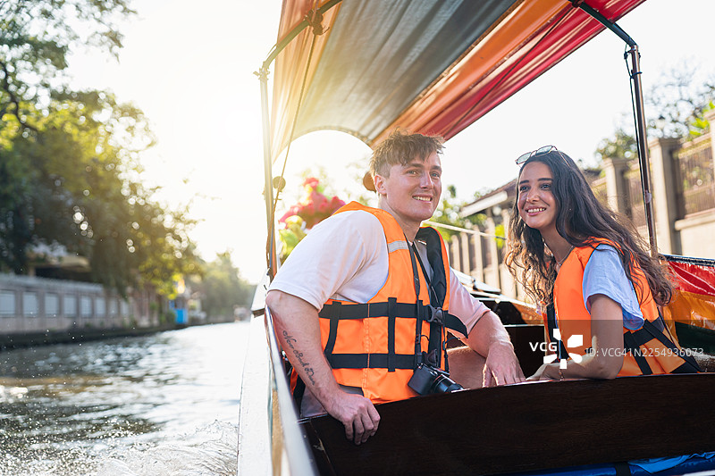 年轻夫妇在曼谷享受长尾船之旅。图片素材