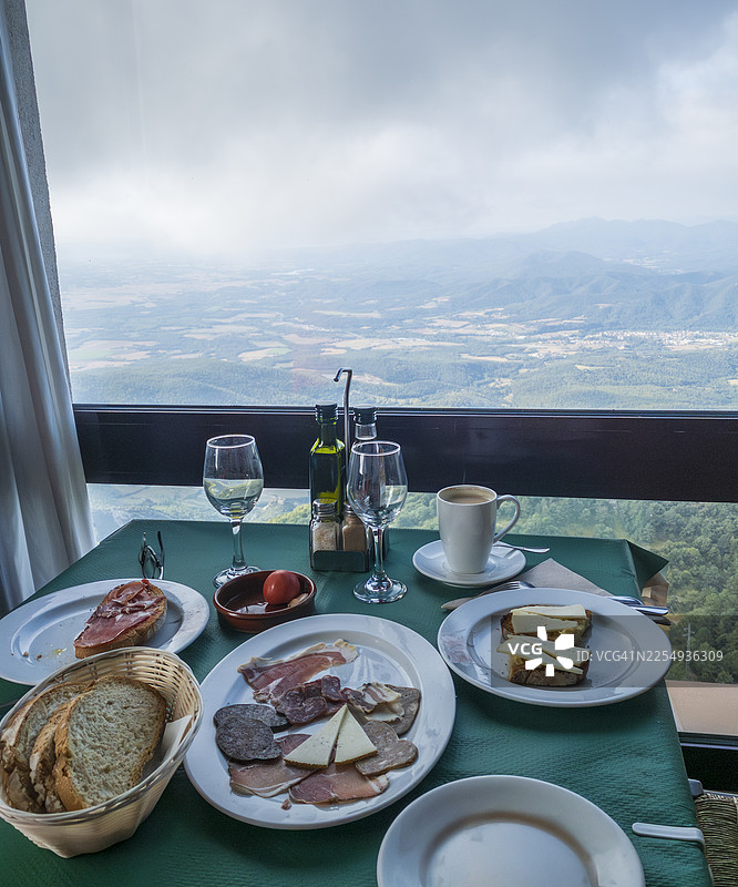 窗边地中海式早餐，有奶酪、火腿和腌制肉，可欣赏山景图片素材