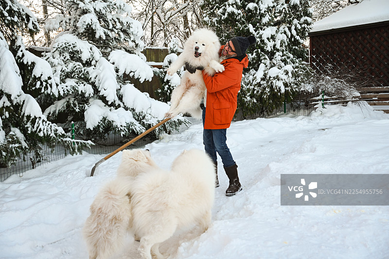 一位成熟的成年男子在花园里铲雪图片素材