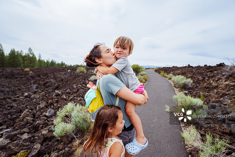 妈妈带着孩子徒步穿越熔岩区图片素材
