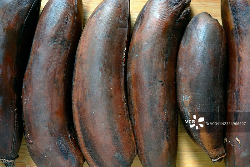 特写镜头下，木制桌面上的过熟香蕉。图片素材