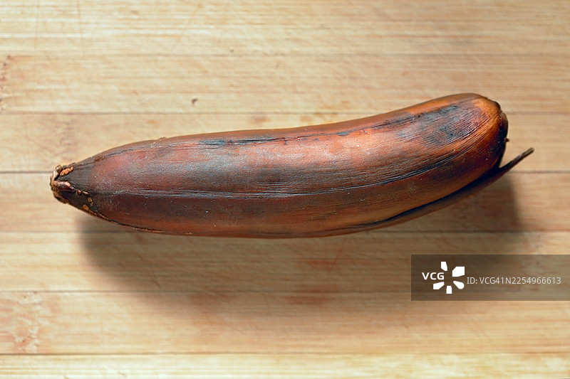 木制桌面上的熟过头的香蕉。图片素材
