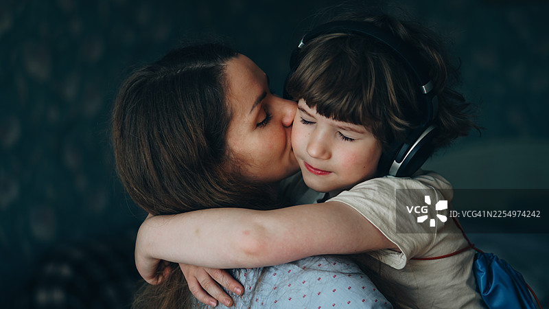 母亲亲吻儿子，紧紧拥抱图片素材