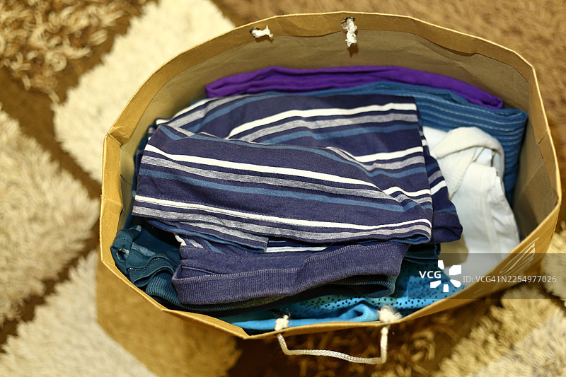 俯视视角，一个装满衣物的可重复使用的棕色纸购物袋图片素材