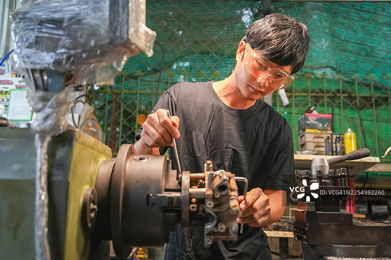 机械师在车间操作设备，工业场景，繁忙的环境，特写镜头，精湛的工艺图片素材