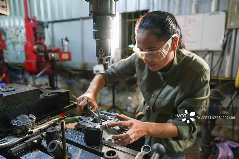 女性在工业车间操作机械，制造过程，车间环境，聚焦的视角，赋权理念图片素材