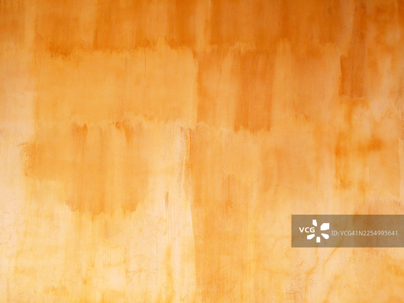 一堵涂刷和做旧成棕色和黄色调的墙壁。西班牙塞维利亚。阳光，自然色彩。图片素材