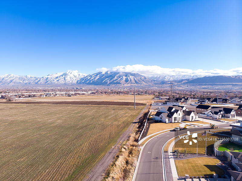 沃萨奇山脉勾勒出郊区的发展。犹他州布拉夫代尔的住宅景观与农田交汇。图片素材