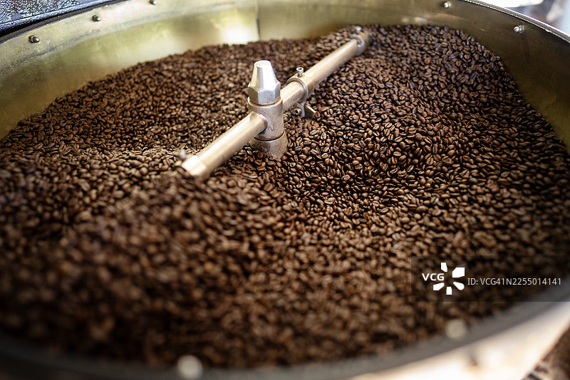 烘焙机中特写烘烤咖啡豆的搅拌过程图片素材