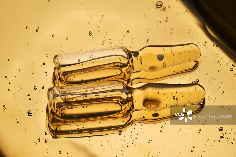 滴管中展示肽的金色面部精华安瓶液体图片素材