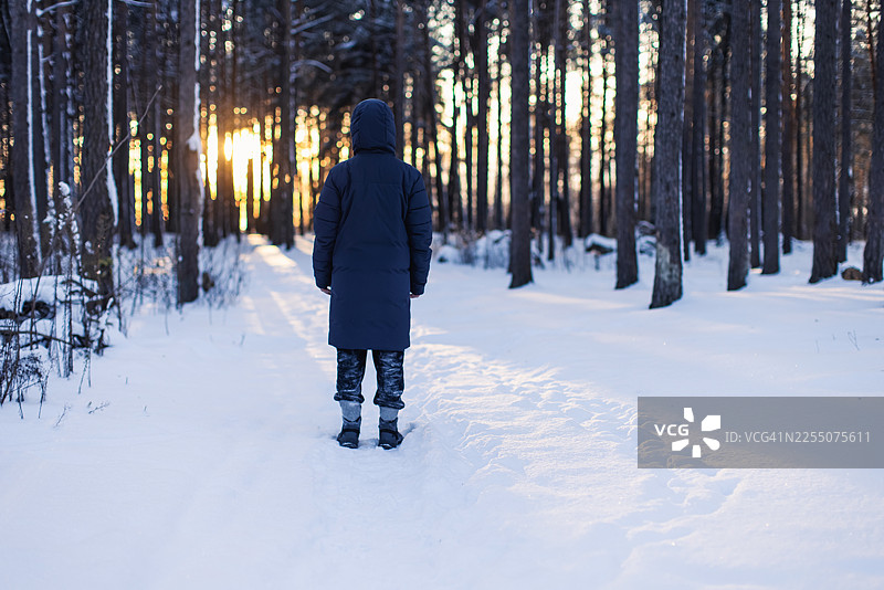 冬日森林中的男性剪影，夕阳余晖图片素材