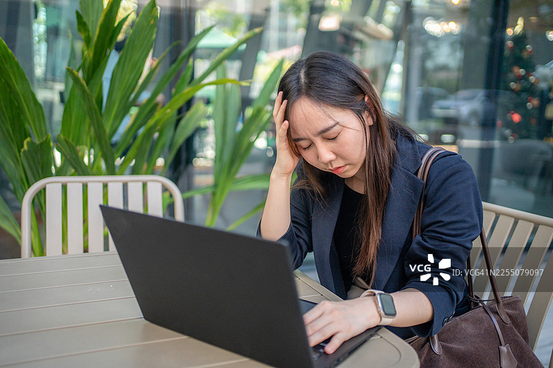 办公室里情绪激动的女子正在使用笔记本电脑。网络仇恨概念图片素材