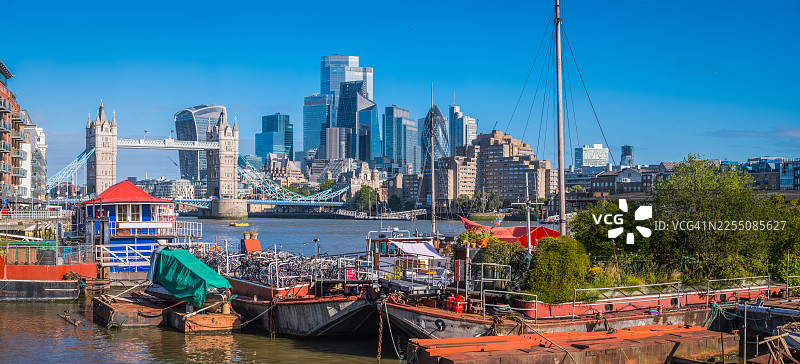 伦敦泰晤士河上的船屋，在摩天大楼林立的伦敦塔桥城市全景的俯瞰下图片素材