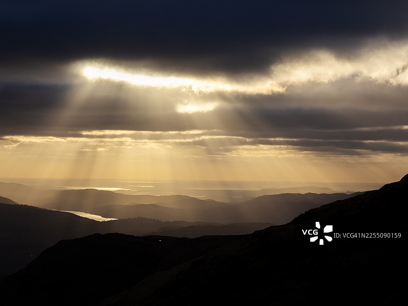 英国湖区红岩山日落时分莫克姆湾的阳光光束图片素材