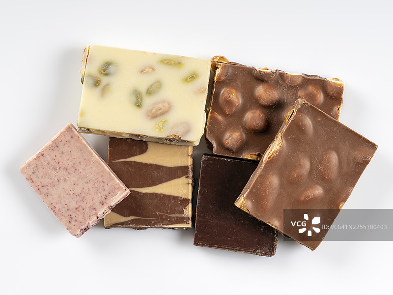 特写镜头，展示六块不同口味的巧克力坚果，在白色背景下切割出来。图片素材