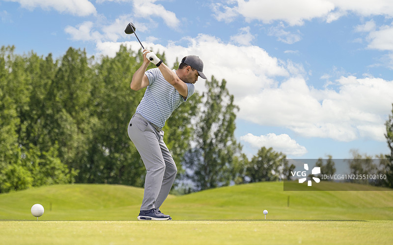 夏季，一位专注的成熟高加索男性高尔夫球手在葱郁的球场上完善他的挥杆动作图片素材