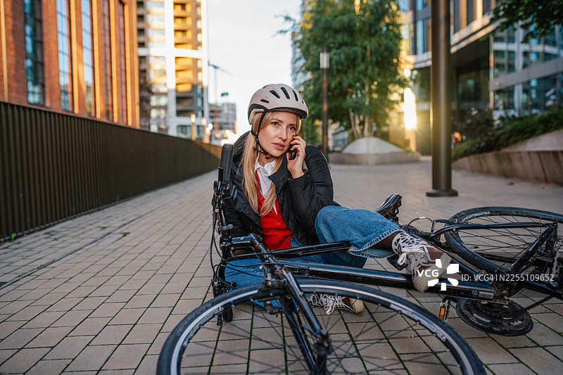 自行车事故后，受伤的女子倒在地上呼救。图片素材