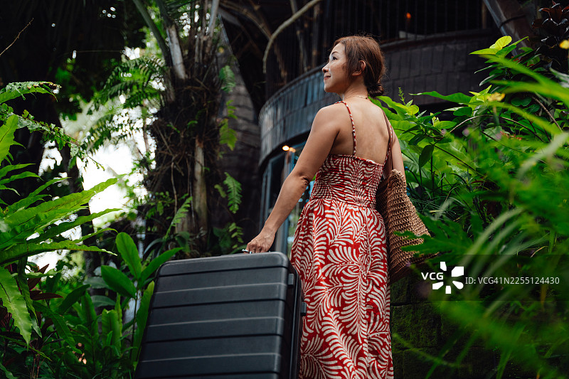 年轻亚洲女性在巴厘岛的特色别墅酒店办理入住图片素材