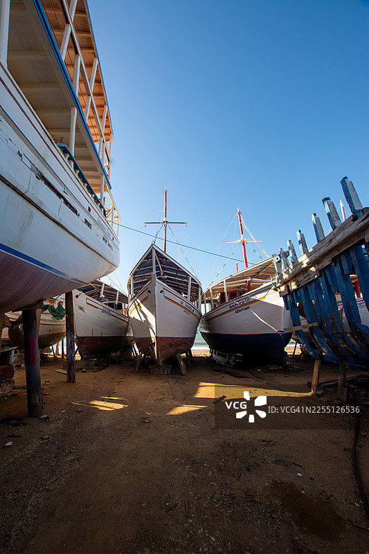 沿海干船坞造船厂内正在修复的商用渔船图片素材