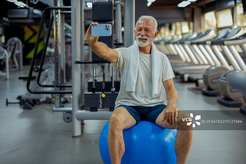健壮的老年男子在健身房自拍图片素材