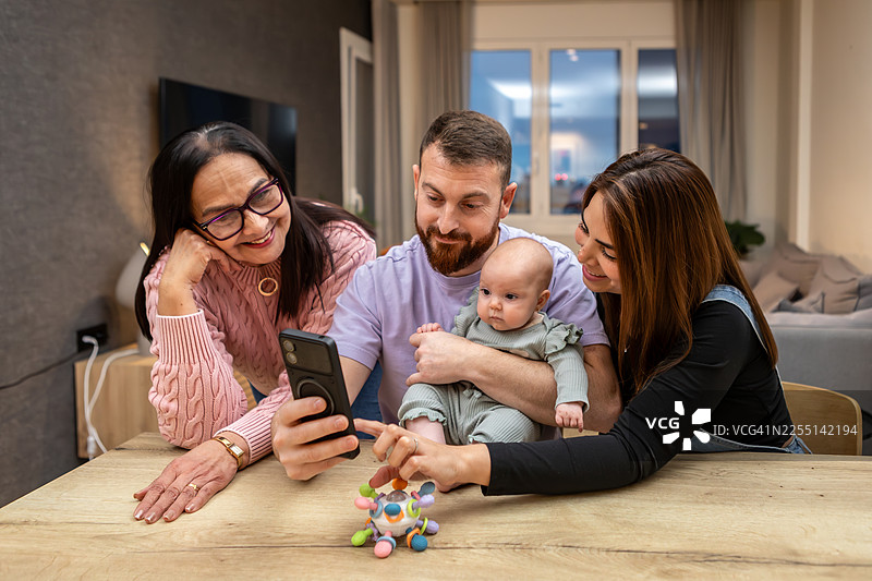 祖孙三代在家中温情相聚，有婴儿和祖母在场图片素材