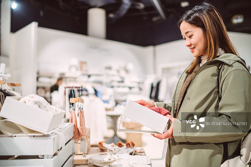 一位母亲在零售店为孩子挑选衣物图片素材