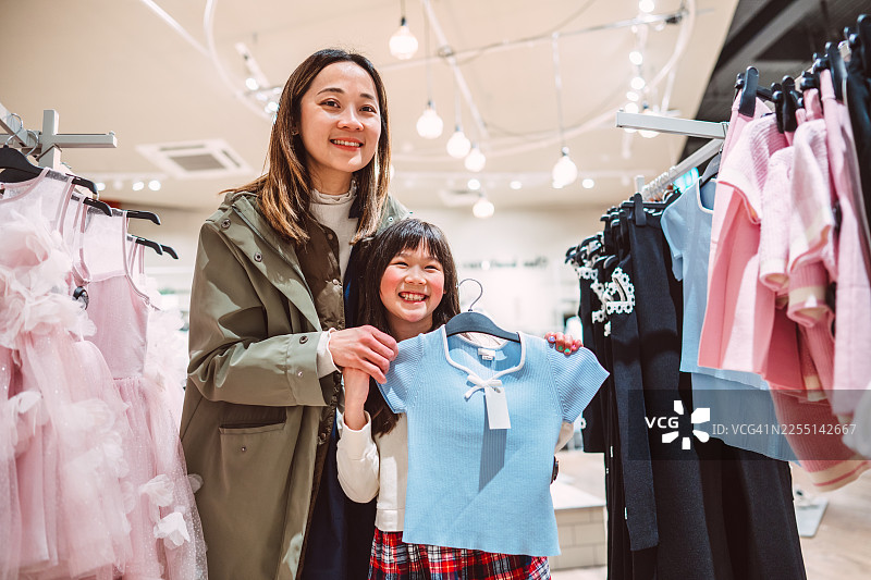 母女在商店里挑选童装图片素材