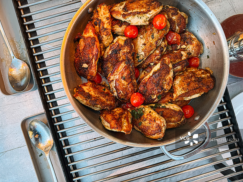 特写镜头：烤鸡胸肉，搭配樱桃番茄，作为专业餐饮自助餐的一部分，为大型团体提供服务图片素材
