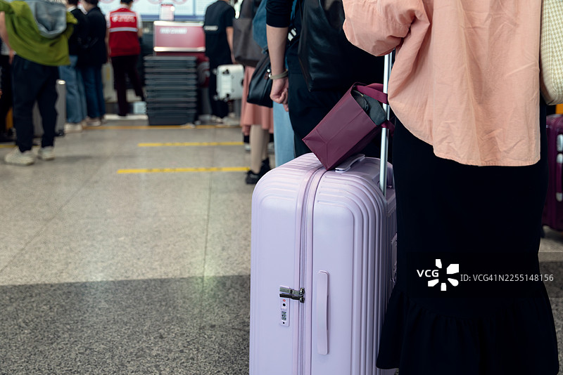 乘客们排队在机场办理行李托运。图片素材