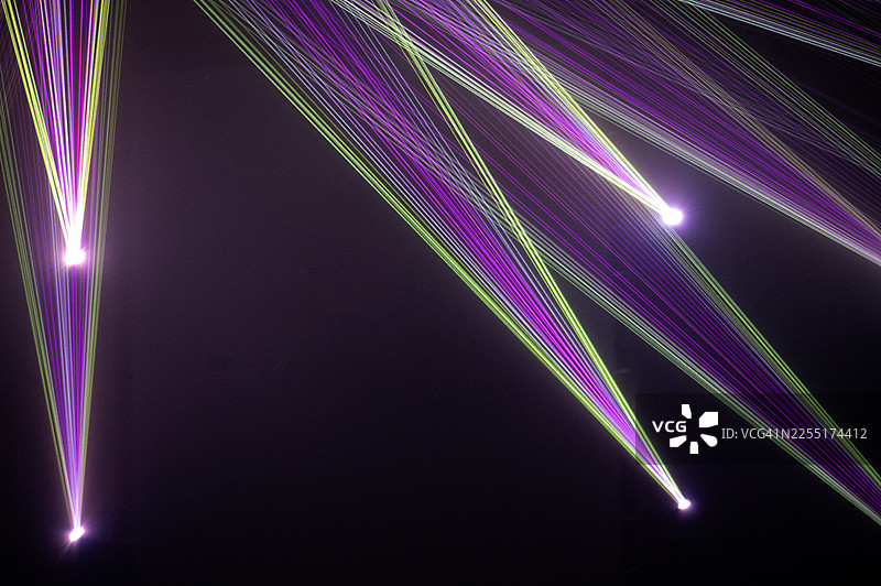深色背景上闪耀着绿色和紫色的光谱线。图片素材