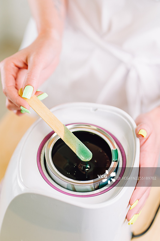 女性准备用于脱毛的糖蜜蜡图片素材